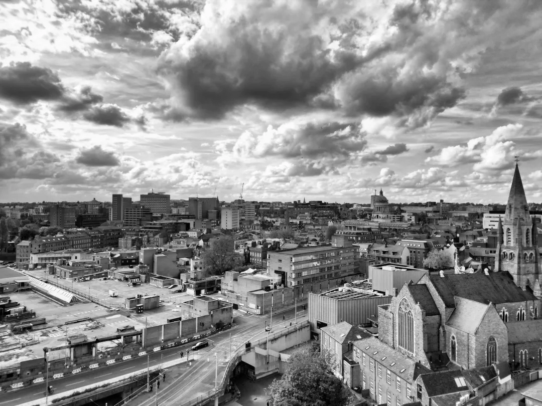 Aerial view over Nottingham city centre rooftops under a dramatic sky