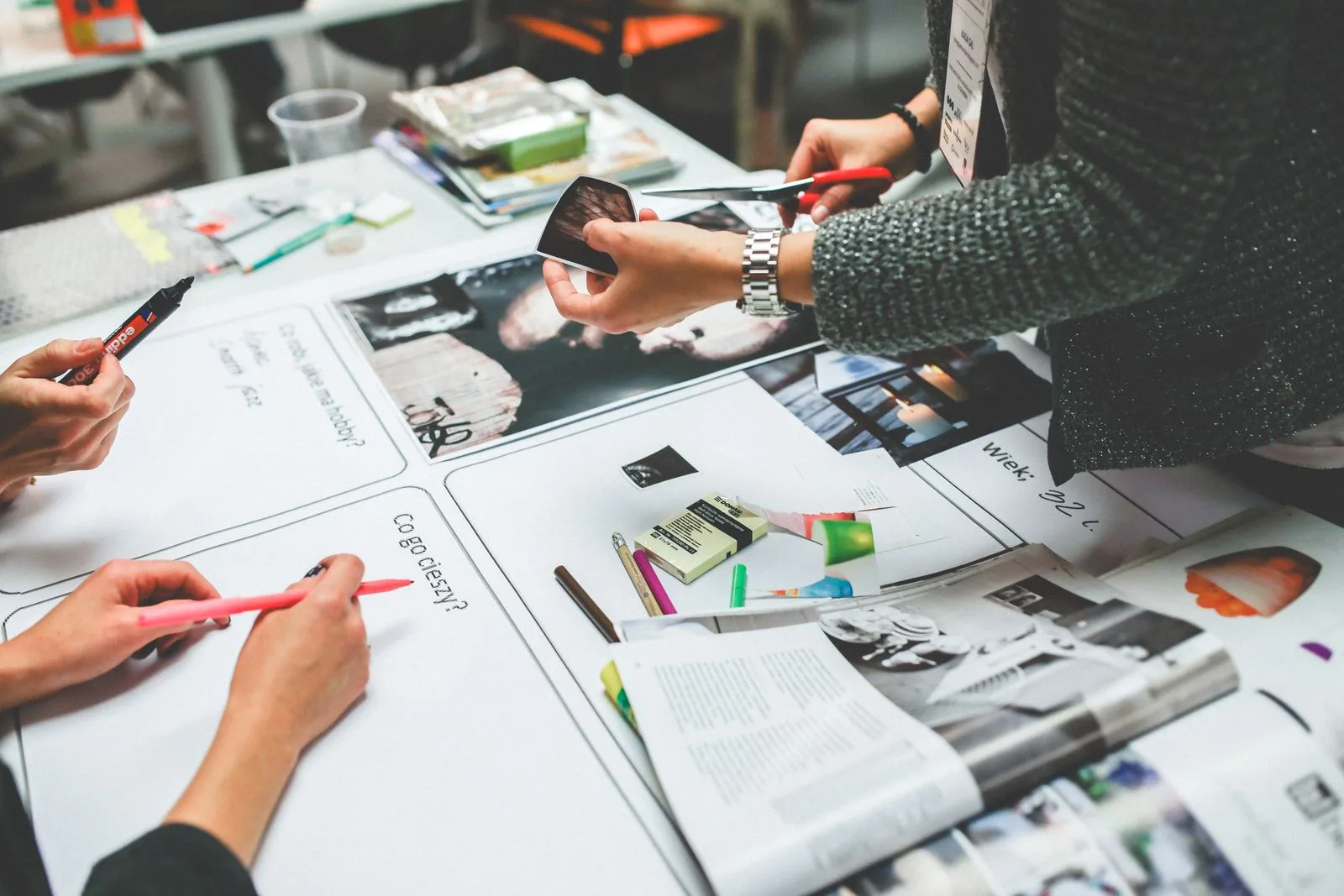 A team reviewing printed designs around a table